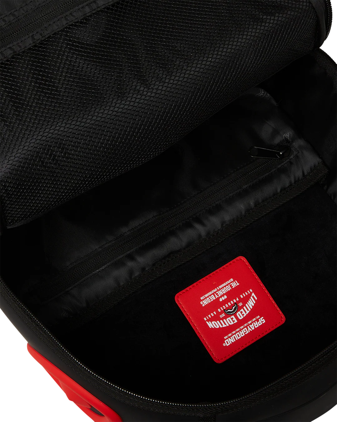 Close-up of a black backpack interior with a red patch featuring text and graphics.