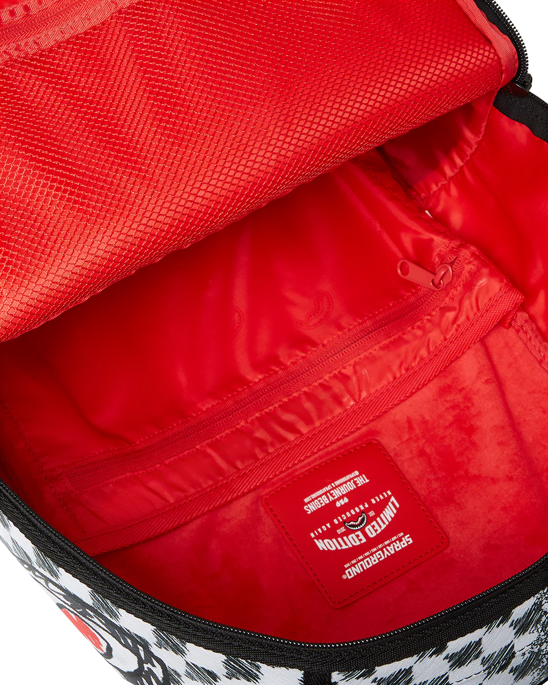 Backpack with checkered pattern and shark mouth design on a white background by the brand sprayground