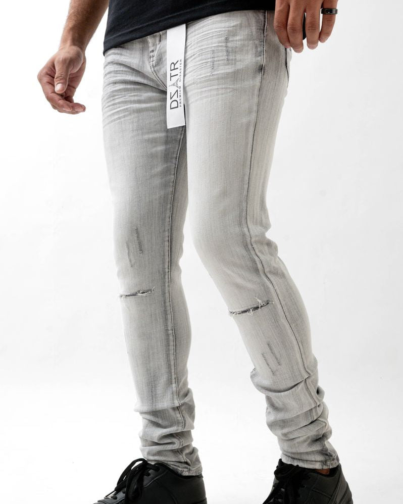 Person wearing light gray jeans with a brand logo on a white background
