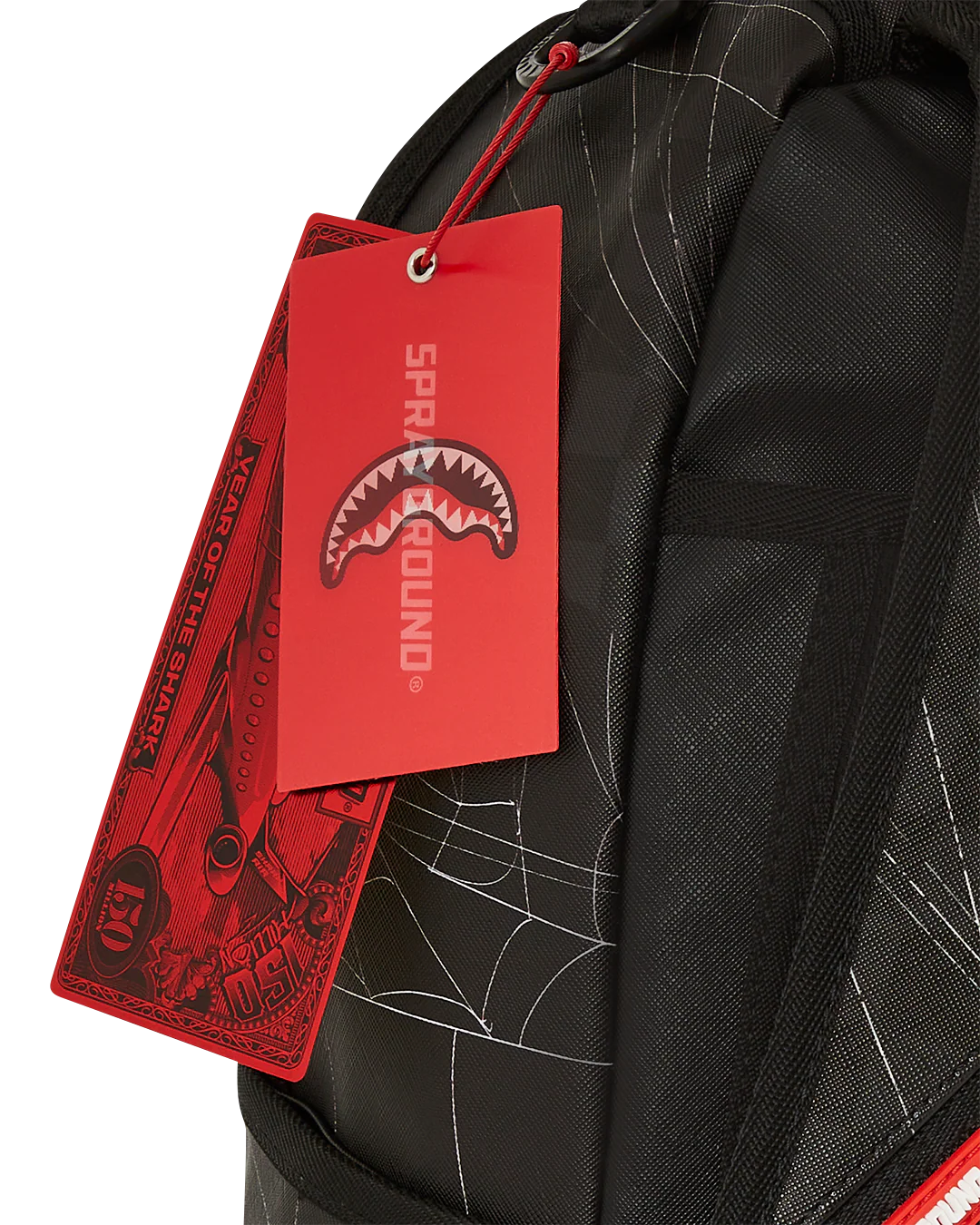 Black backpack with a red tag featuring a shark logo and brand name.