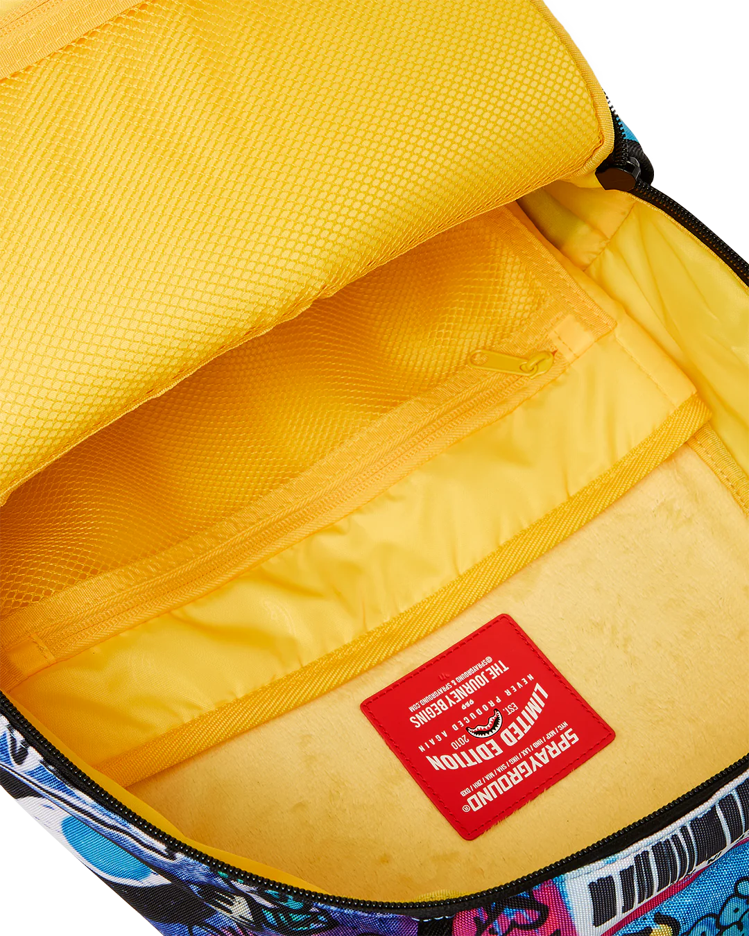 Yellow interior of a bag with a red label featuring the Sprayground logo on a white background