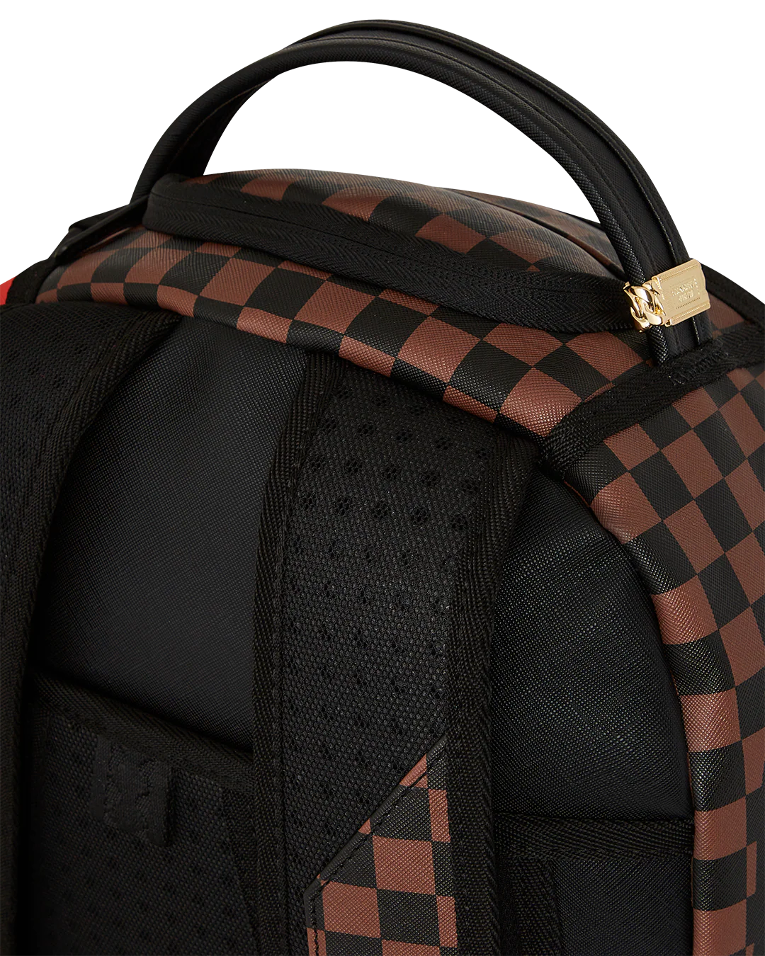Close-up of a black and brown checkered backpack with a gold zipper pull.