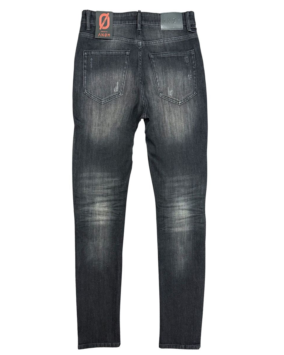 Back view of a pair of black distressed jeans on a white background