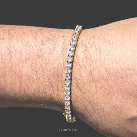 Person wearing a gold tennis bracelet on a wrist 