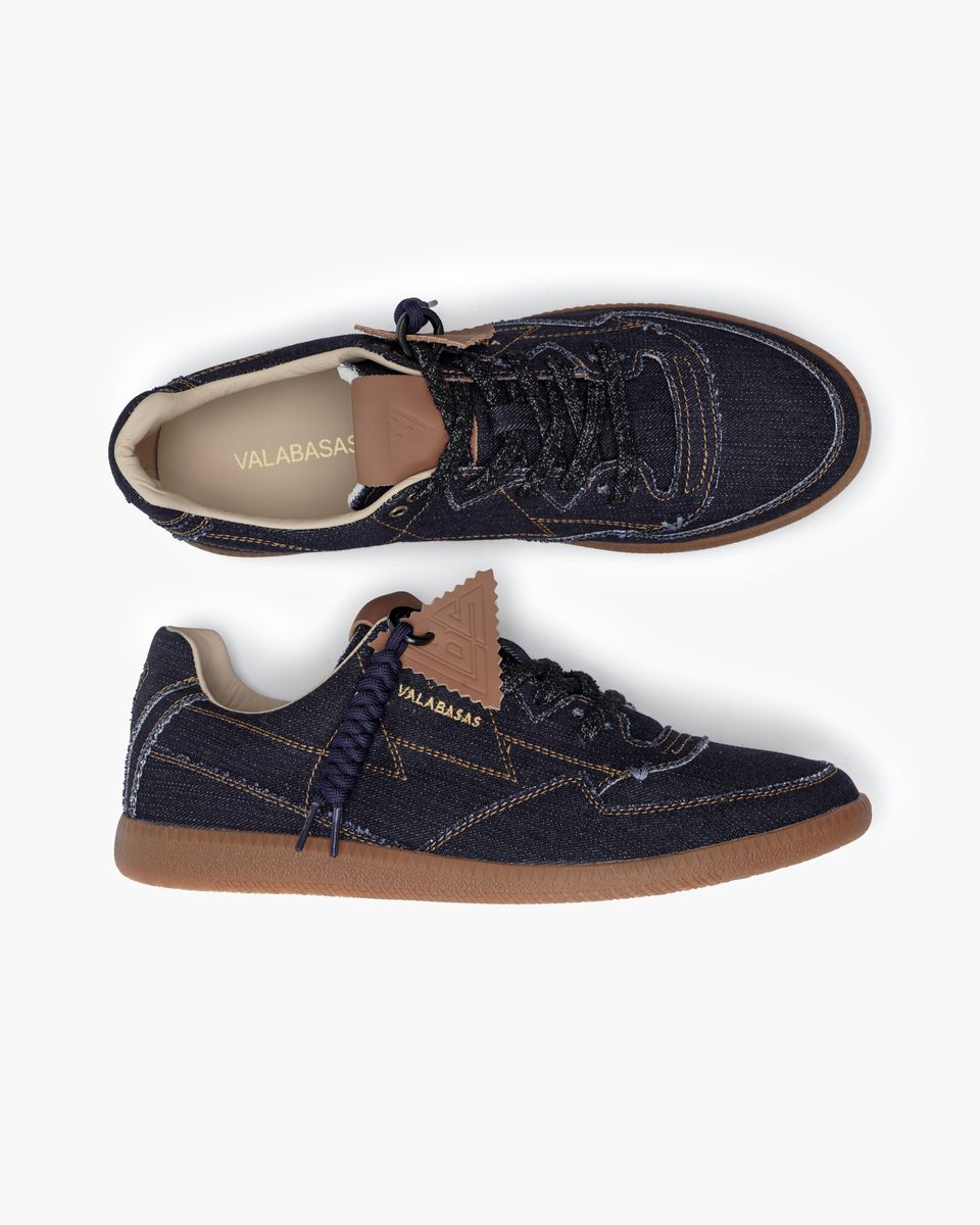 Pair of navy blue sneakers with brown soles on a white background