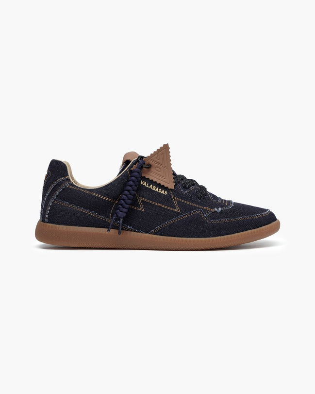 Black slip-on sneaker with white sole on a light gray background
