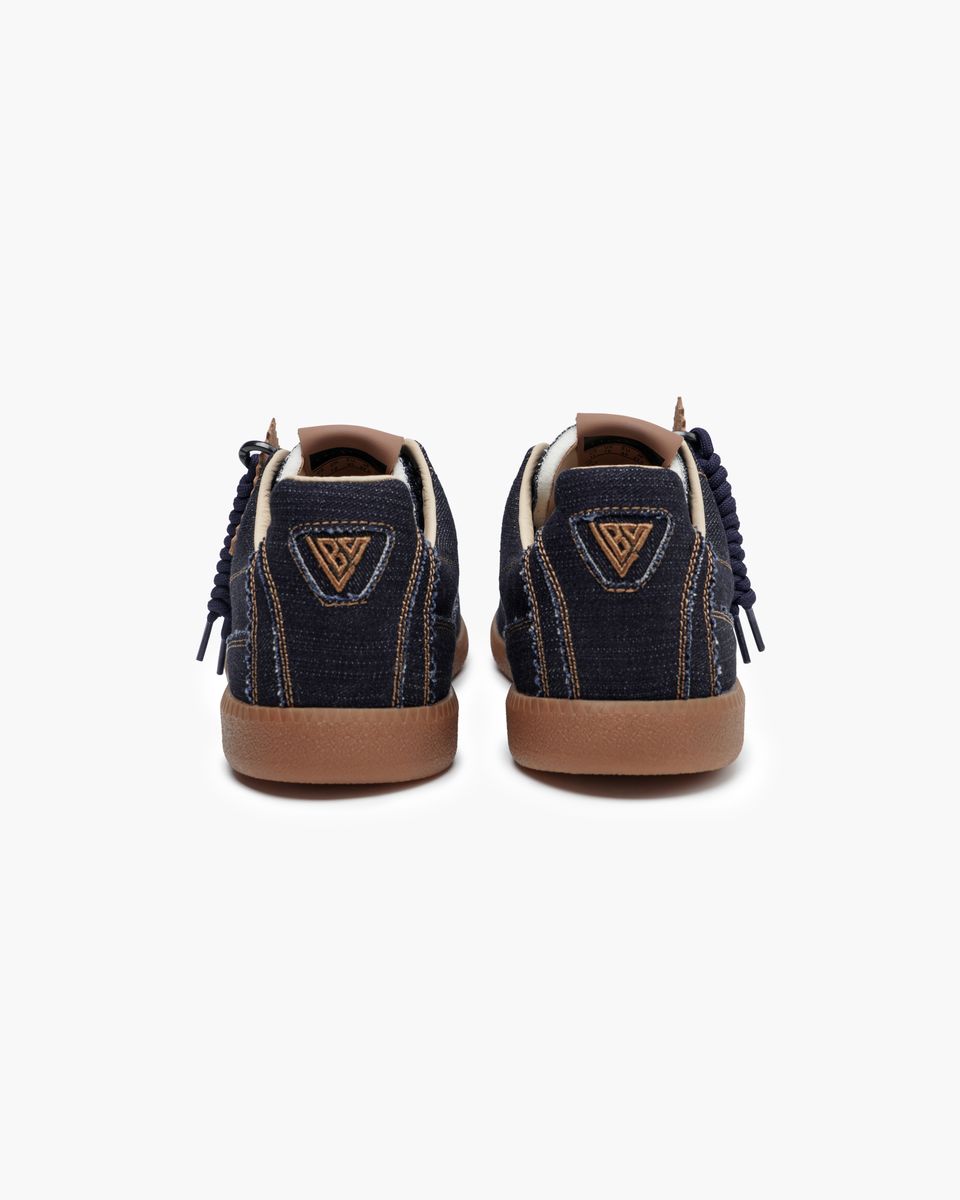 Pair of navy blue sneakers with brown soles on a white background