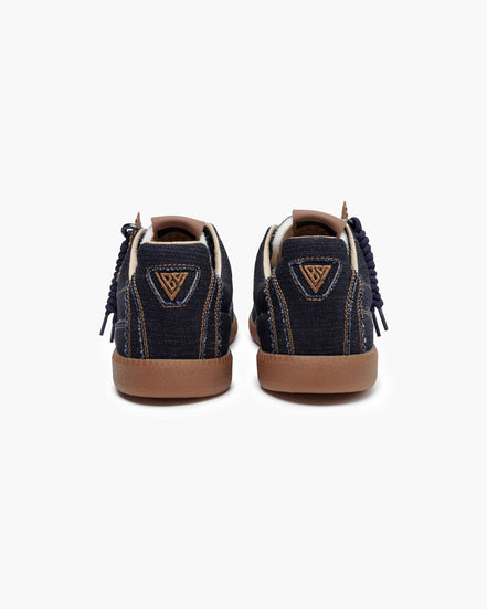 Pair of navy blue sneakers with brown soles on a white background