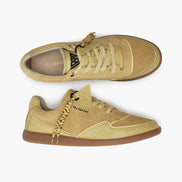 Pair of yellow sneakers with visible branding on a white background
