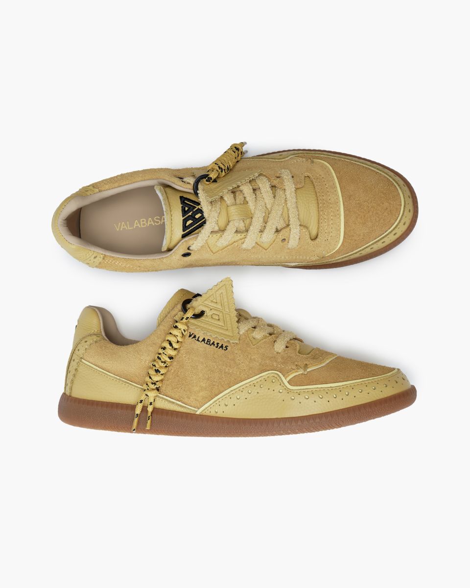 Pair of yellow sneakers with visible branding on a white background