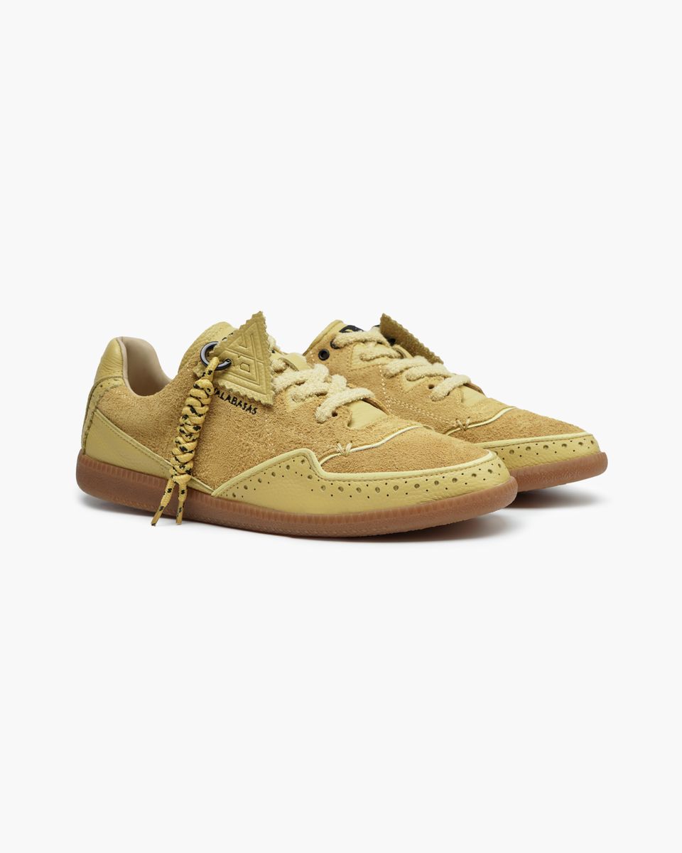 Pair of yellow sneakers with a white background