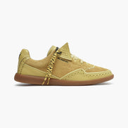 Yellow sneaker with brown sole on a white background