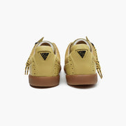 Pair of yellow beige sneakers with brown soles on a white background