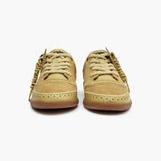 Pair of yellow tan sneakers on a white background