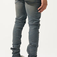 Person wearing gray jeans and white sneakers on a white background