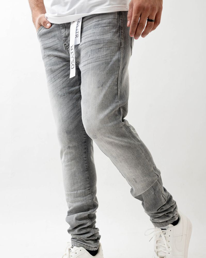 Person wearing gray jogger pants and white sneakers on a white background