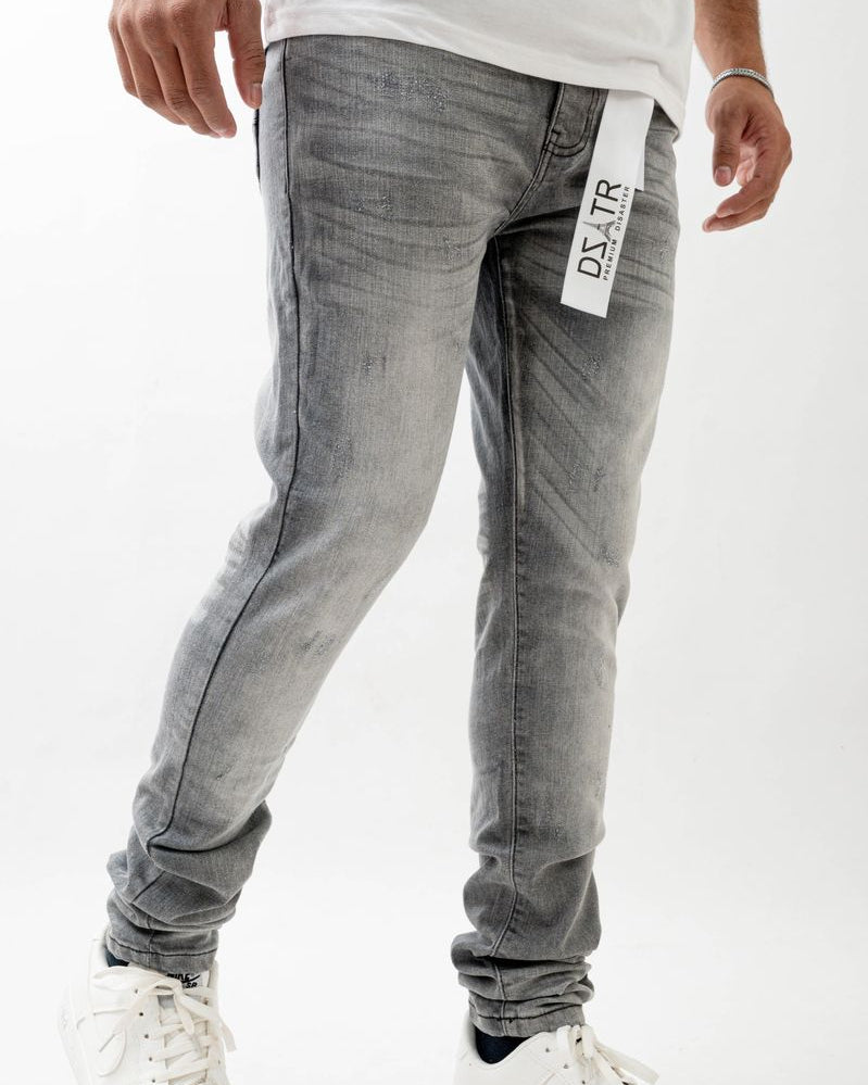 Person wearing gray jeans with a visible brand tag on a white background