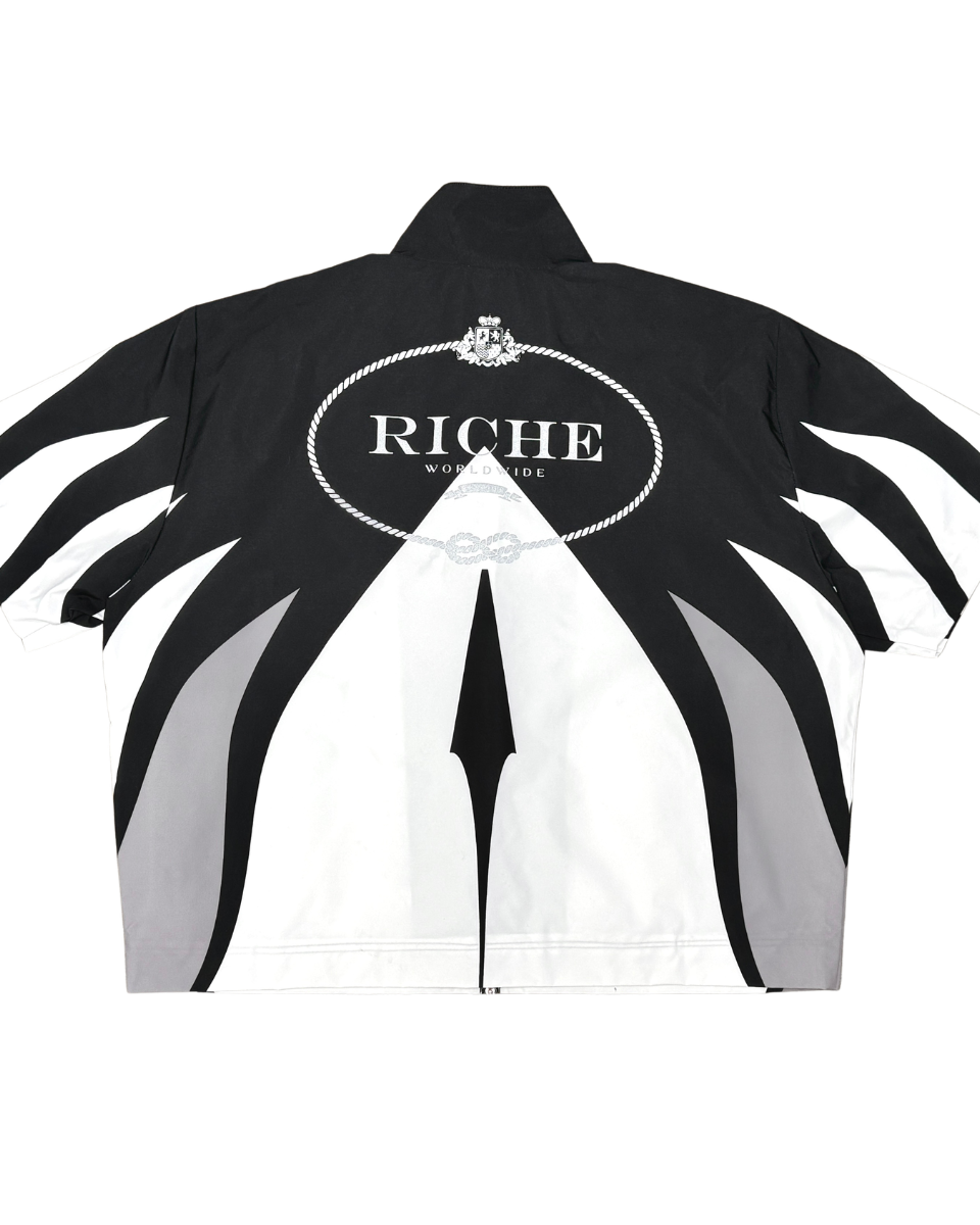 Black and white jacket with 'Riche' branding on a white background