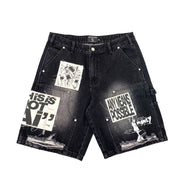 Black denim shorts with graphic designs on a white background
