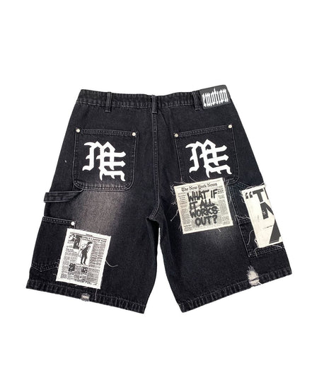 Black denim shorts with newspaper print and branding on a white background