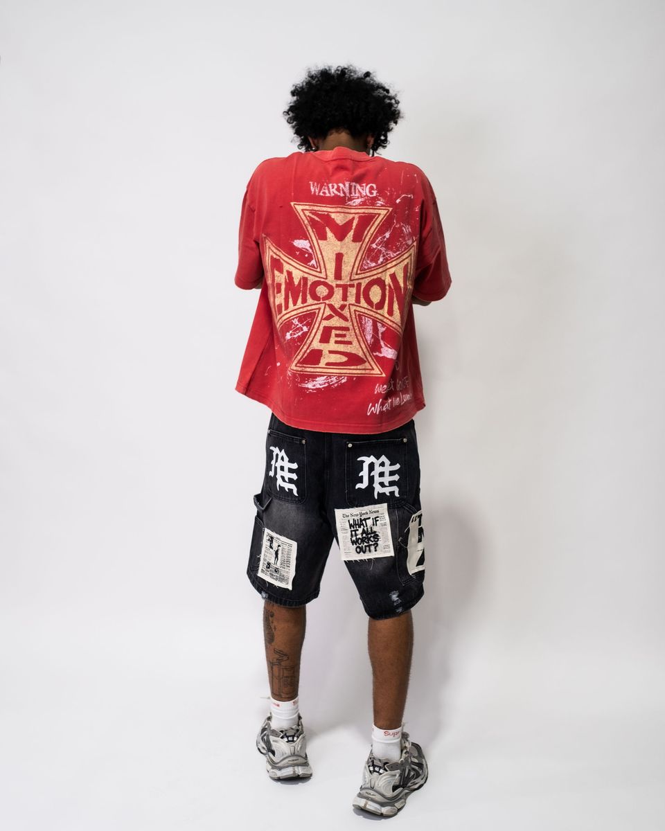 Person wearing a red t-shirt with graphic design and black shorts with white text on a white background