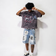 Person wearing a graphic t-shirt and denim shorts on a white background
