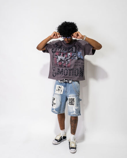 Person wearing a graphic t-shirt and denim shorts on a white background