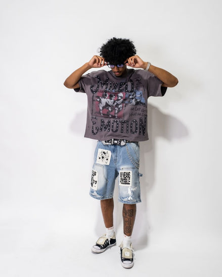 Person wearing a graphic t-shirt and denim shorts on a white background