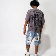 Person wearing a graphic t-shirt and patchwork shorts on a white background