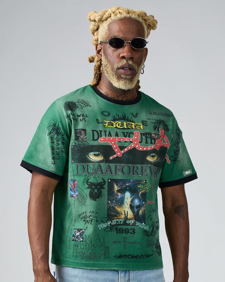 Man wearing a green t-shirt with graphic designs and text