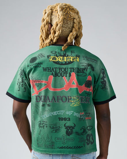 Person wearing a green t-shirt with text and graphics on the back, standing against a plain background.