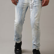 Person wearing light blue distressed jeans with a gray background