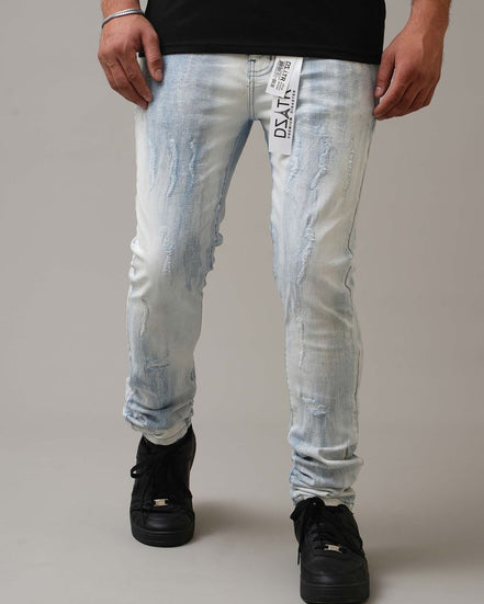 Person wearing light blue distressed jeans with a gray background