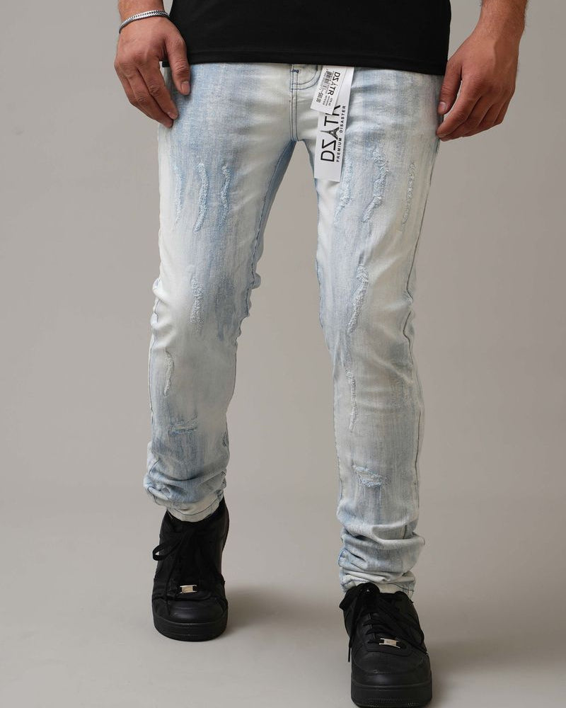 Person wearing light blue distressed jeans with a gray background