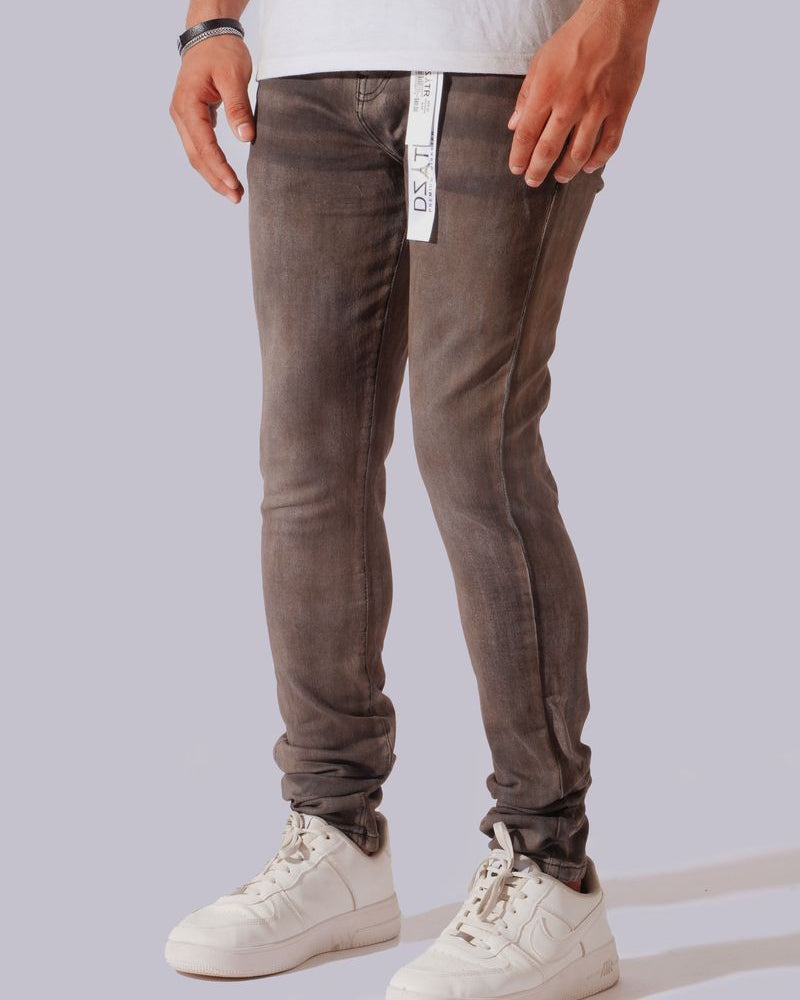 A person wearing slim-fit gray washed jeans with a white waistband tag, paired with a white t-shirt and white sneakers, shown from the waist down against a light gray studio background.