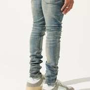 Person wearing light blue jeans and gray sneakers on a white background