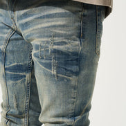 Close-up of distressed blue jeans on a white background