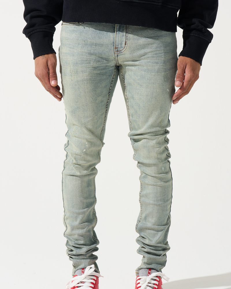 Person wearing light blue jeans and red sneakers on a white background