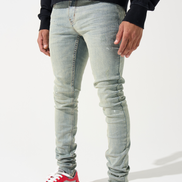 Person wearing light blue jeans and red sneakers on a white background