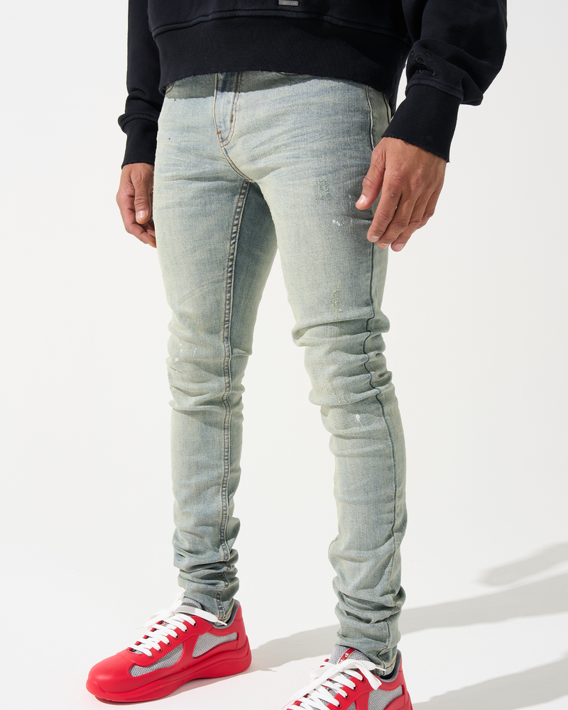 Person wearing light blue jeans and red sneakers on a white background