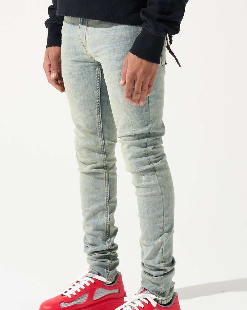 Person wearing light blue jeans and red sneakers on a white background