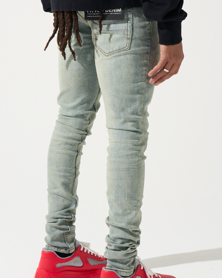 Person wearing light blue jeans and red sneakers on a white background