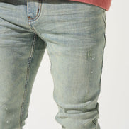 Close-up of light blue jeans and a red sweatshirt on a white background