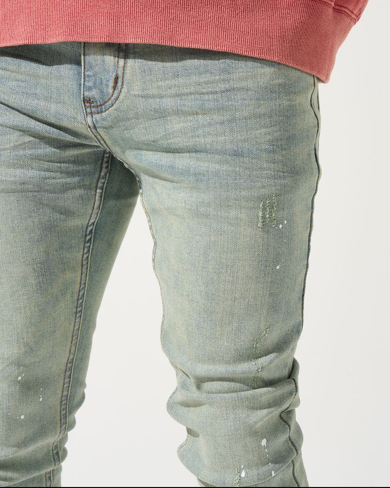 Close-up of light blue jeans and a red sweatshirt on a white background