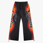 Black pants with orange and red graphic design on a white background