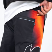 Black pants with a colorful design on the leg, held by a person.