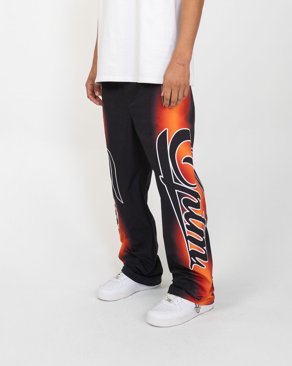 Person wearing black and orange pants with a logo on a white background