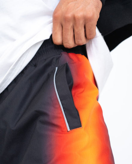Close-up of a person wearing a jacket with a gradient design transitioning from black to orange.