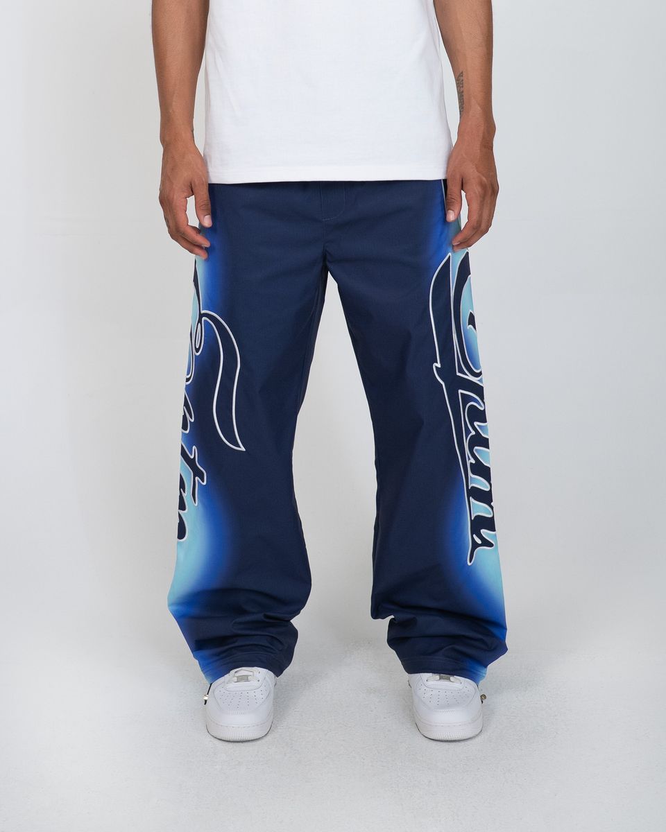 Person wearing blue sweatpants with white text on a plain background