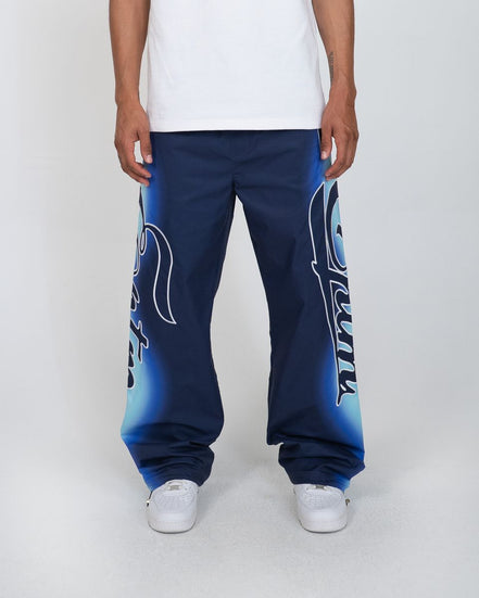 Person wearing blue sweatpants with white text on a plain background